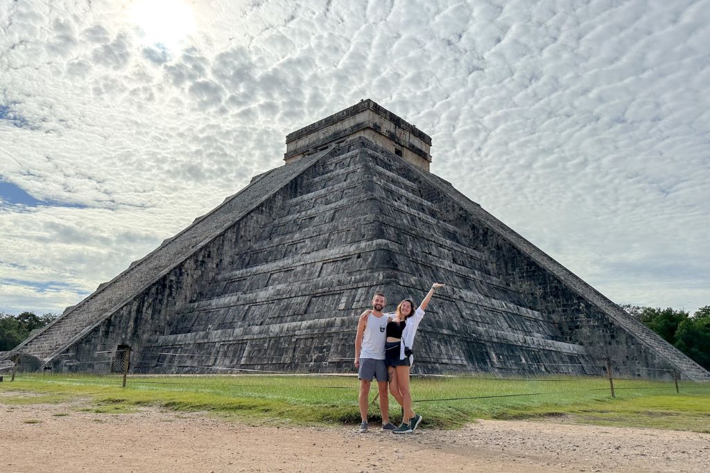 A couple standing in front of chichen itza mayan ruins in Mexico