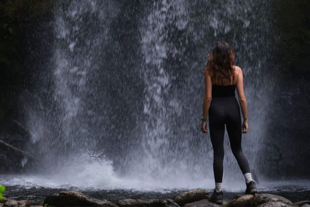 Girl dramatically posing in front of a waterfall in Boquete, Panama
