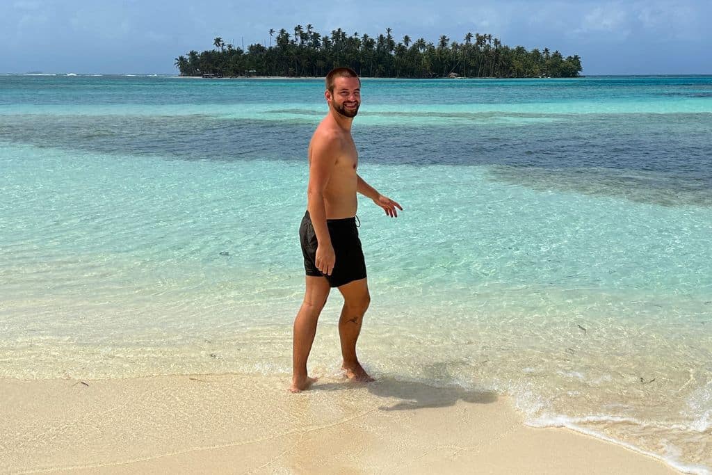 Man entering the crystal clear waters of San Blas