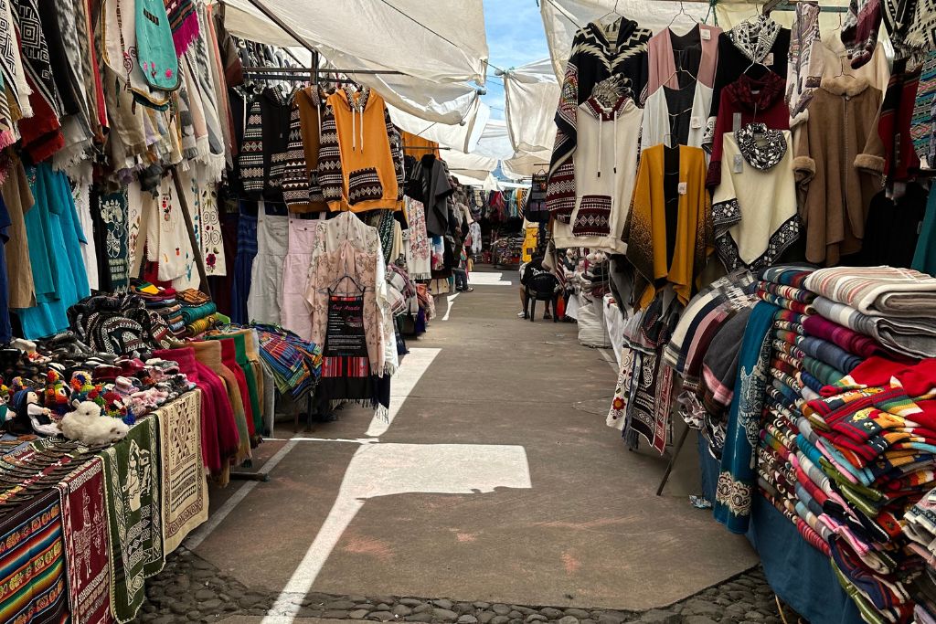 A narrow path through market stalls on Plaza de Ponchos in Otavalo