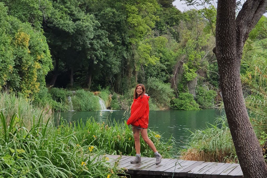 a girl on a wooden walkway over the beautiful blue waters at Krka National park in Croatia