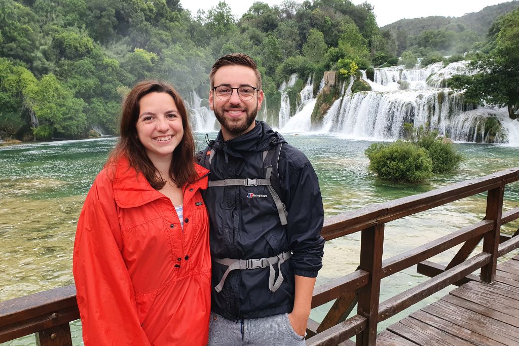 a couple standing in front of large waterfalls in Croatia