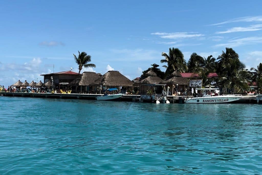 view of the beach huts and boats from the sea in belize