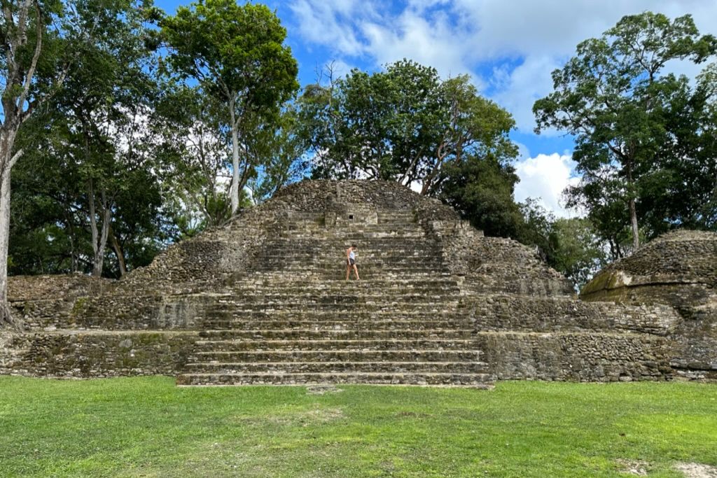 a girl standing on a giant mayan tempe in the jungle in Belize