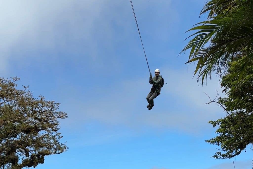 A man swinging in the sky from a long rope