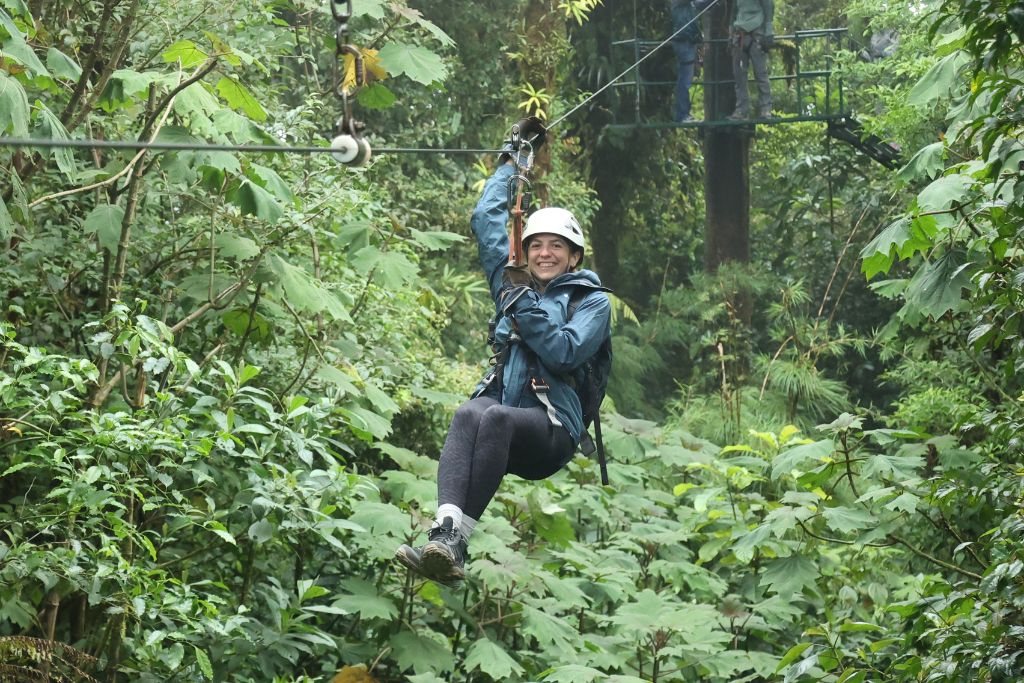 A girl smiling as she zip lines through the cloud forest in Costa Rica