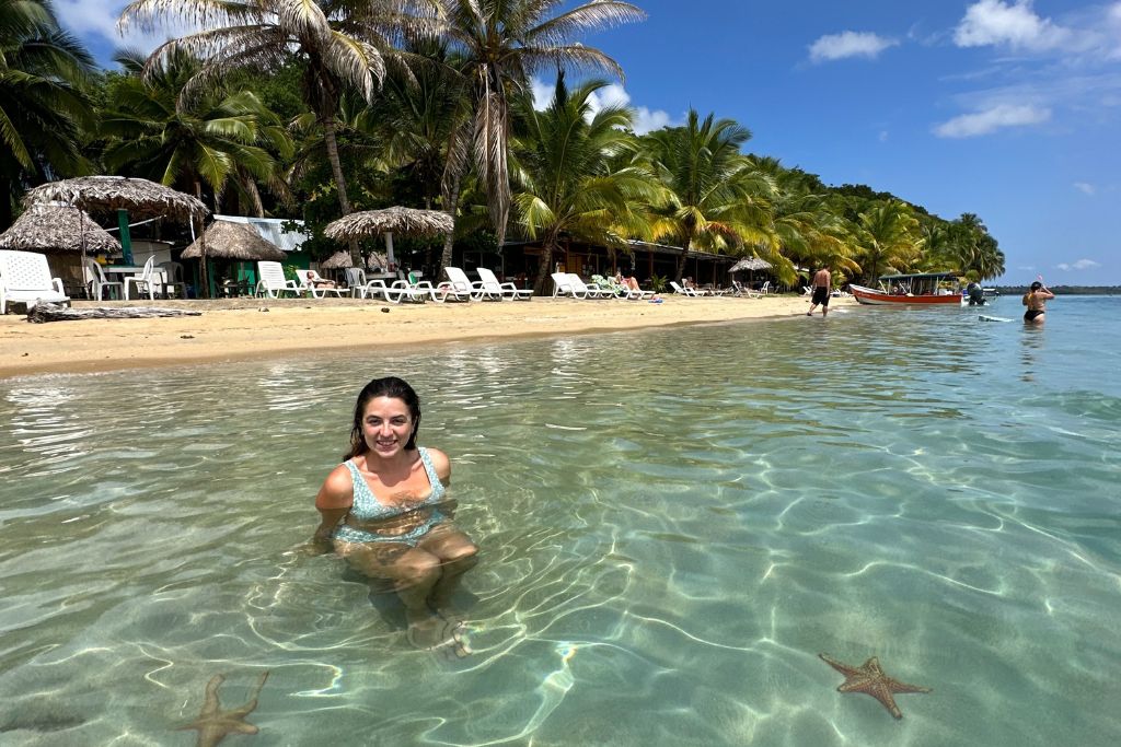 A girl sitting in the sea on a beautiful beach on Bocas Del Toro